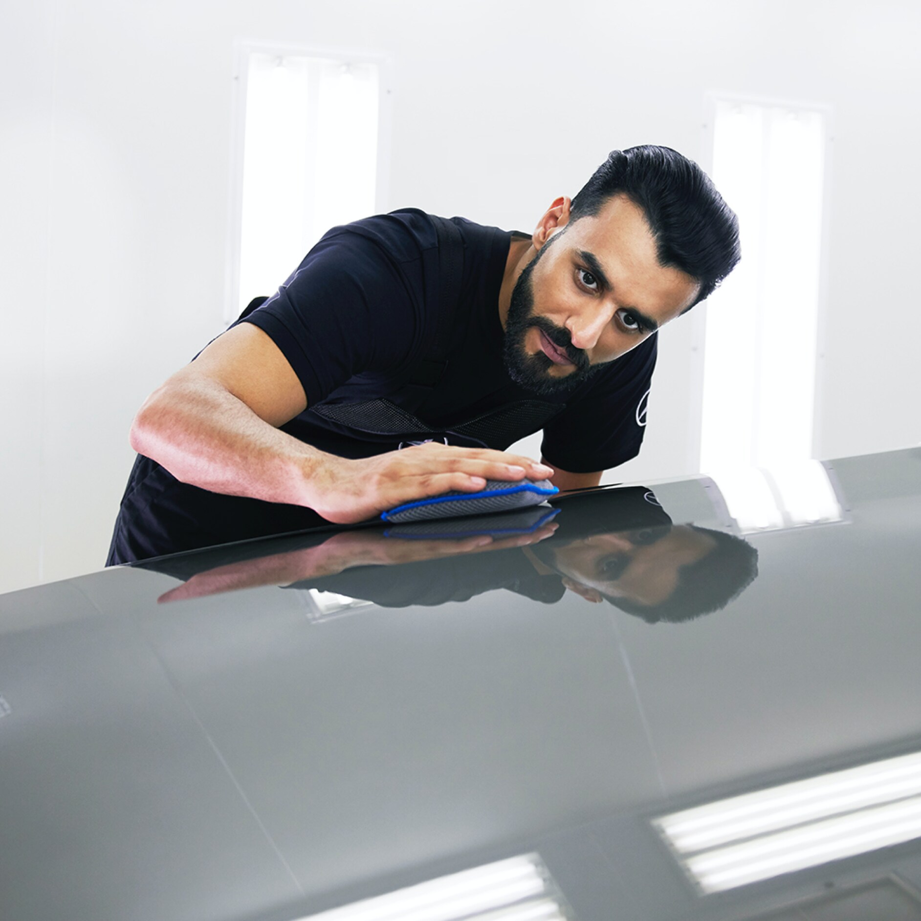 SmallRepair Un técnico de Mercedes-Benz examina el capó en busca de pequeños desperfectos.