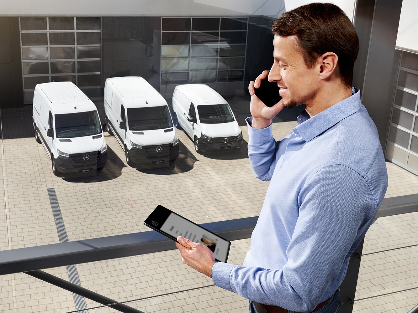 Tienda Mercedes-Benz | Extras digitales | Mercedes-Benz Una persona con un smartphone delante de una Mercedes-Benz Vito.